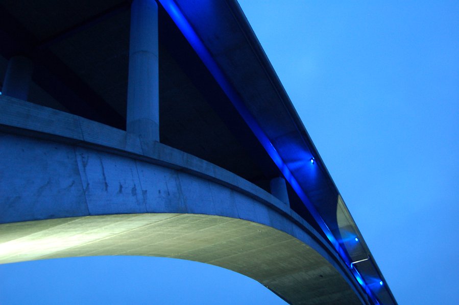 Bro i betong upplyst av blått ljus.