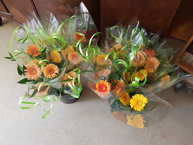 Blombuketter inslagna i cellofan. Blommorna går i gult och orange.