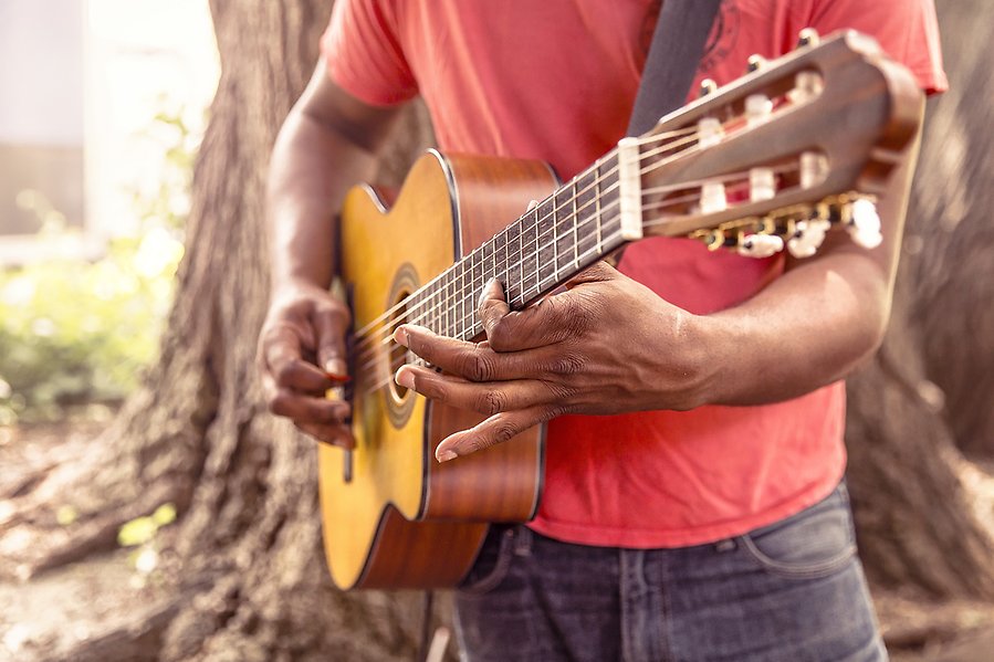 En man som spelar på en gitarr.