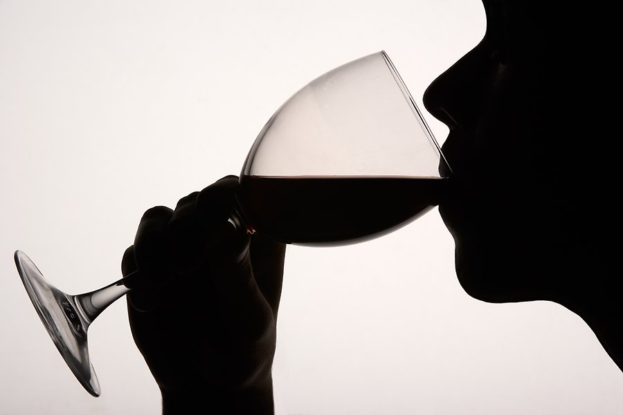 Bild i siluett av person som dricker ur ett vinglas