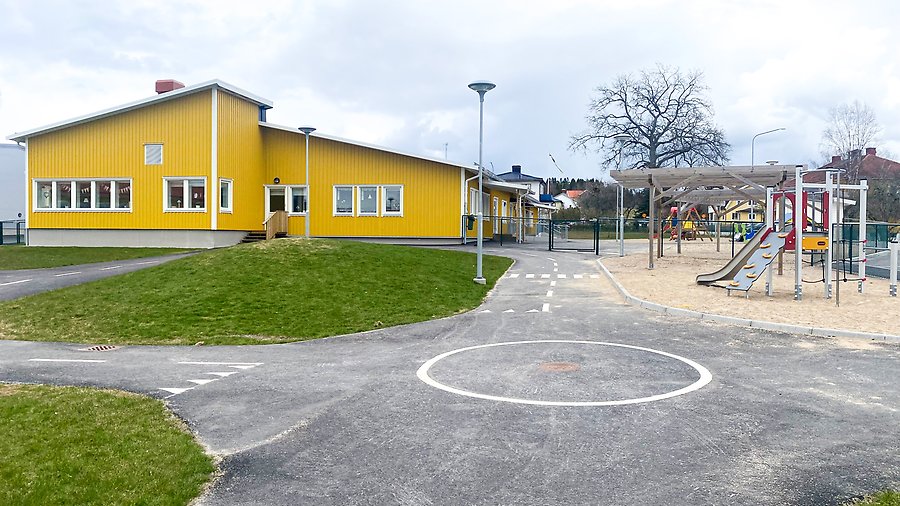 Förskolebyggnad med en lekplats på utsidan