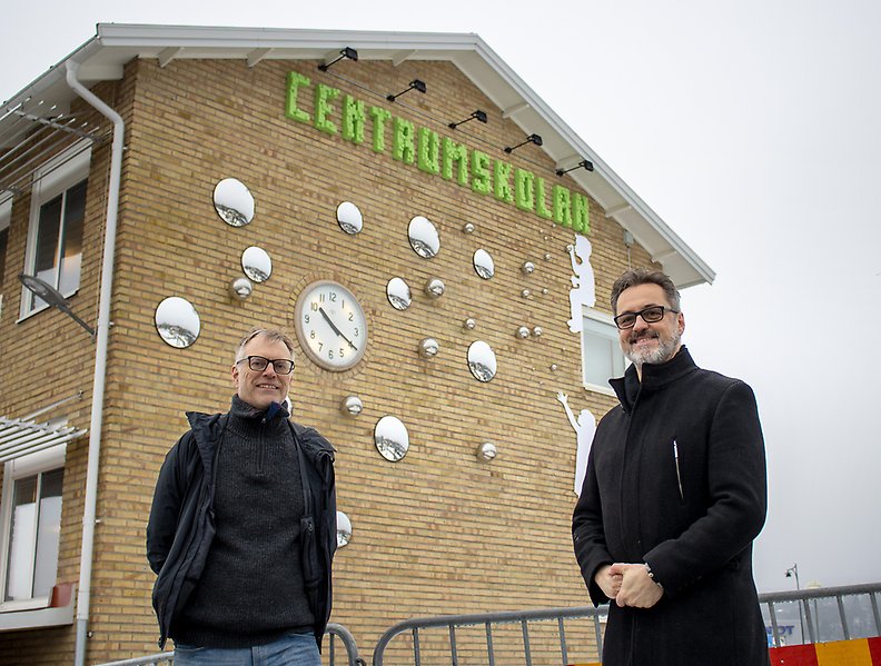 Kulturutvecklare JanOlof Karlsson och konstnären Sinisha Bozunovic står framför konstverket på Centrumskolan i Dingle.