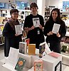 Foto på tre kvinnor som håller upp varsin bok. Framför dem syns ett podie med fler böcker.