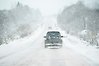 Bilar på landsväg i snöoväder