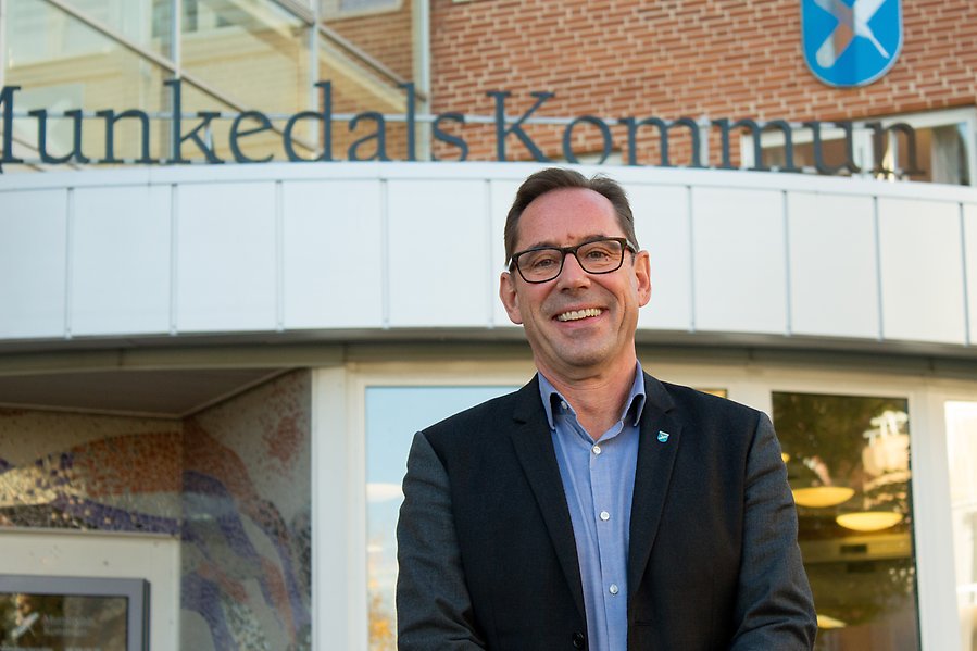 Kommunchef Håkan Sundberg står framför entrén till Munkedals kommunhus
