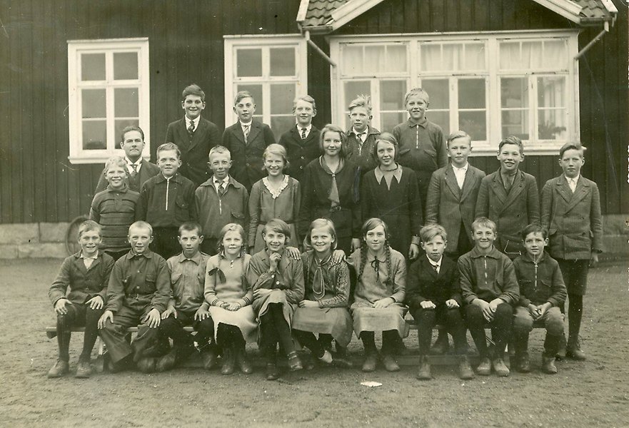 Foto på en skolklass från 1930-talet framför ett äldre hus.