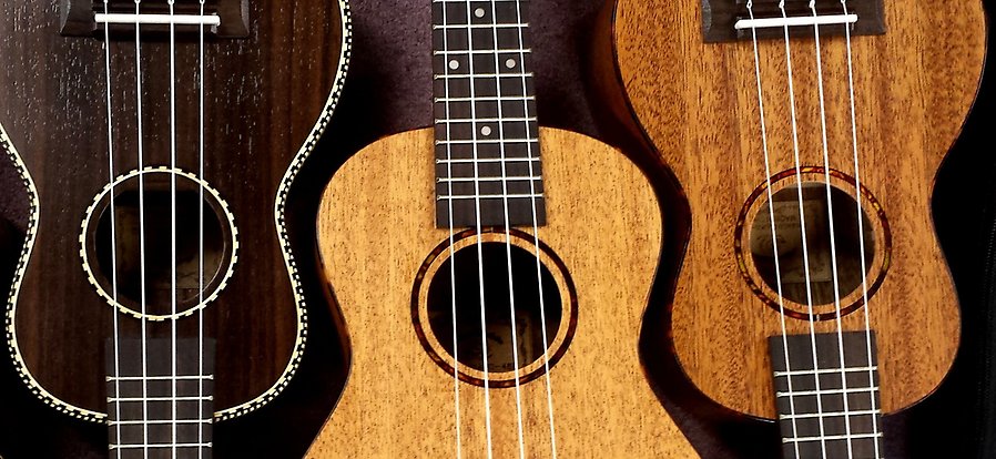 En närbild på tre ukulele, ser ut som små gitarrer.