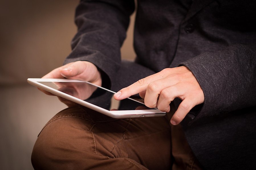 En man som pekar med sitt finger på en ipad.