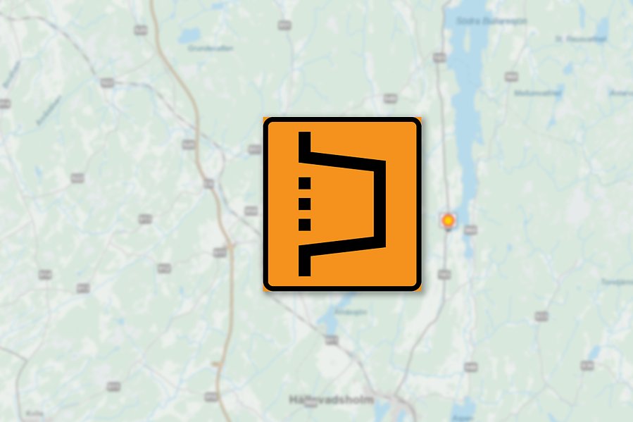 En orange omledningsskylt. I bakgrunden en suddig vägkarta.