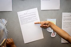 Hand som pekar på en upphängd text