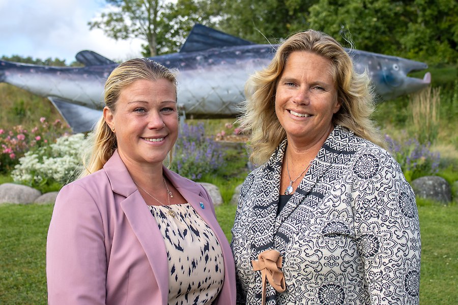 Två leende personer i en park.