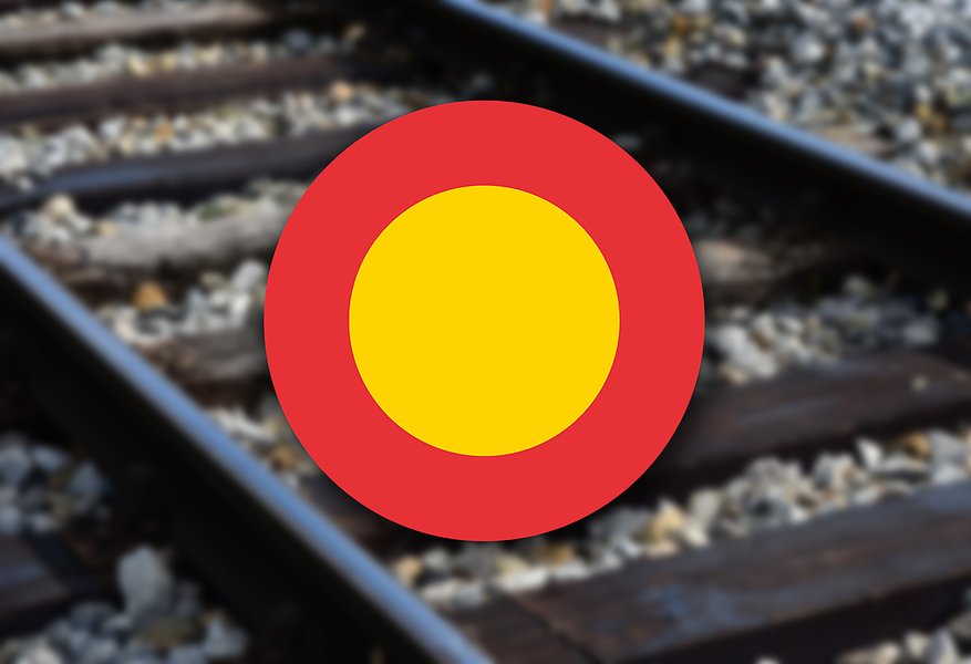 En skylt med fordonstrafik förbjuden. I bakgrunden ett järnvägsspår.
