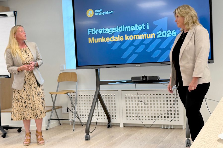 Två kvinnor som står vid en skärm. På skärmen står det Företagsklimatet i Munkedals kommun 2026.