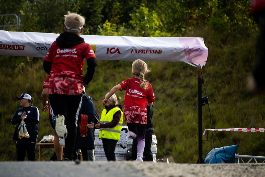 Målgång i Lilla Blodomloppet. En kille och en tjej springer i mål.