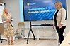 Två kvinnor som står vid en skärm. På skärmen står det Företagsklimatet i Munkedals kommun 2026.