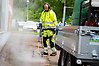 En man som bekämpar ogräs med hjälp av hett vatten som ångar.