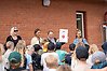 Fyra kvinnor står på en scen varav en håller upp ett diplom. Det står barn i publiken.