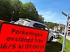 Vägskylt som visar att en parkeringsplats kommer att vara avstängd. I bakgrunden flera parkerade bilar.
