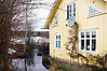 Ett gult hus som är omgärdat av vatten på grund av en översvämning.
