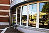 Ett glasparti och en entrédörr. Nedanför fönstren står en cykel parkerad. I ett av fönstren syns en skylt med texten InfoPoint.