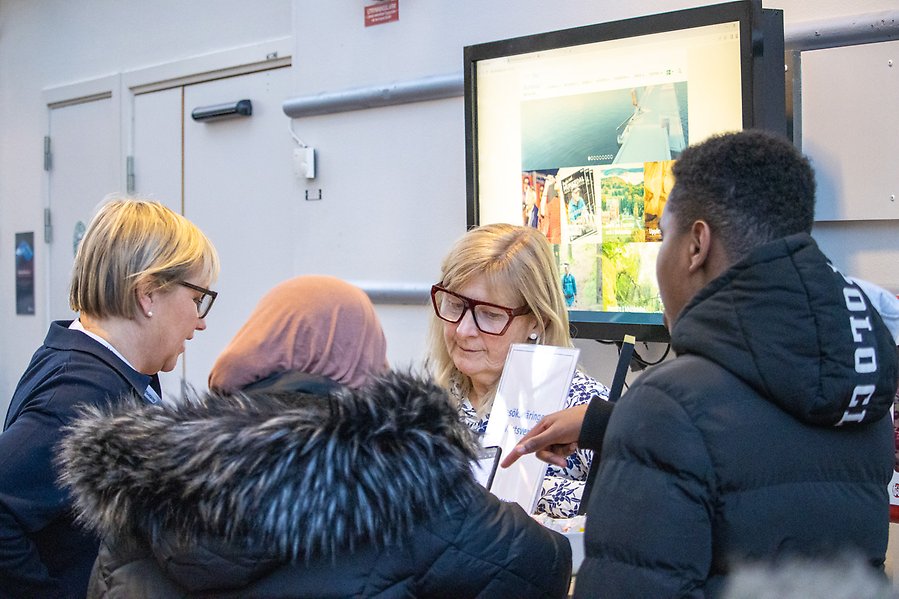 Två personer som diskuterar med två andra personer