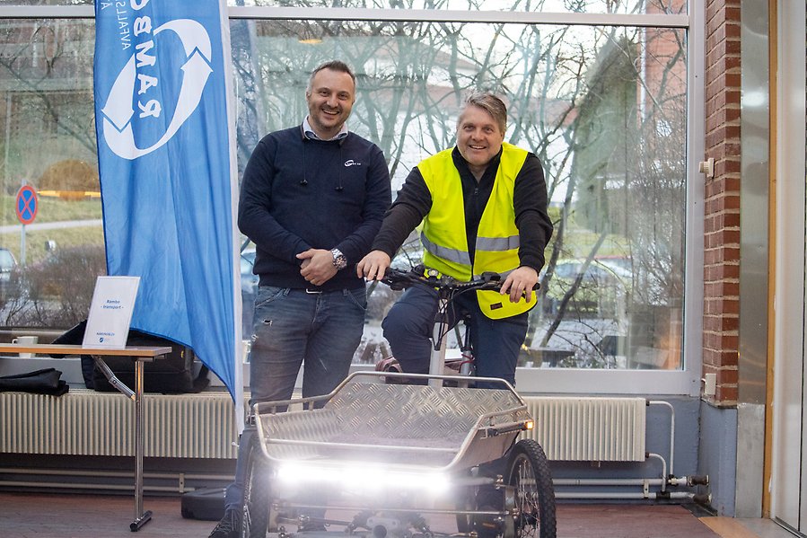 Två personer vid en transportcykel