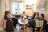 Flera personer sitter i en soffa och diskuterar böcker