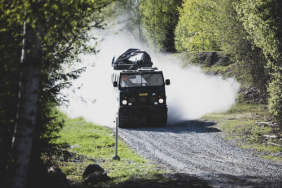 Bandvagn åker på en grusväg i skogen
