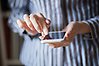 Person som pekar på sin mobiltelefon